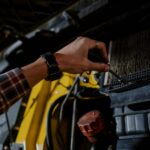 Najczęstsze usterki Changana po 100 tys km na co uważać przy zakupie auta z drugiej ręki Mechanik sprawdza silnik samochodu Changan śrubokrętem