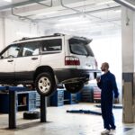 Mechanik sprawdza uniesionego SUV-a w nowoczesnym warsztacie