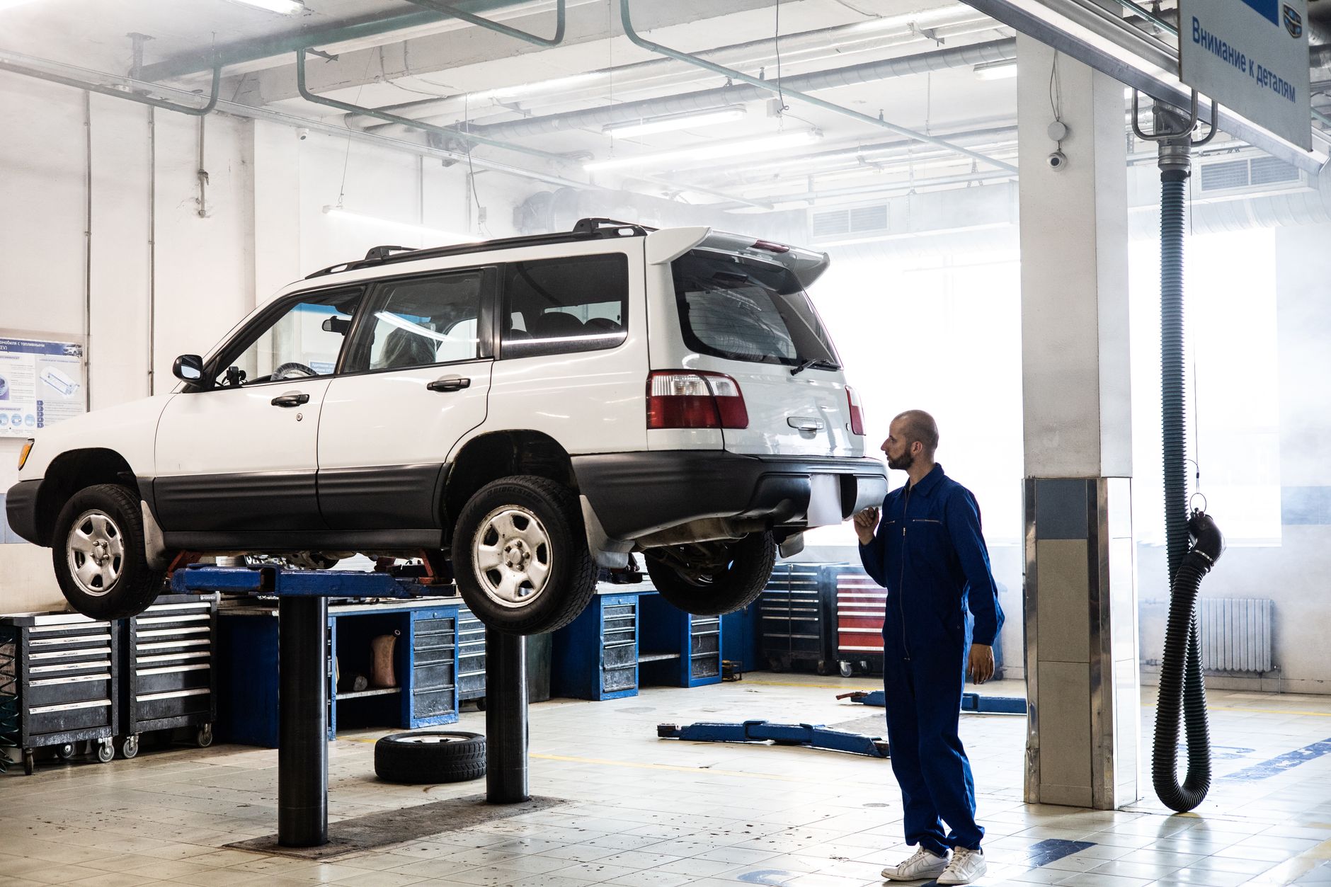 Mechanik sprawdza uniesionego SUV-a w nowoczesnym warsztacie