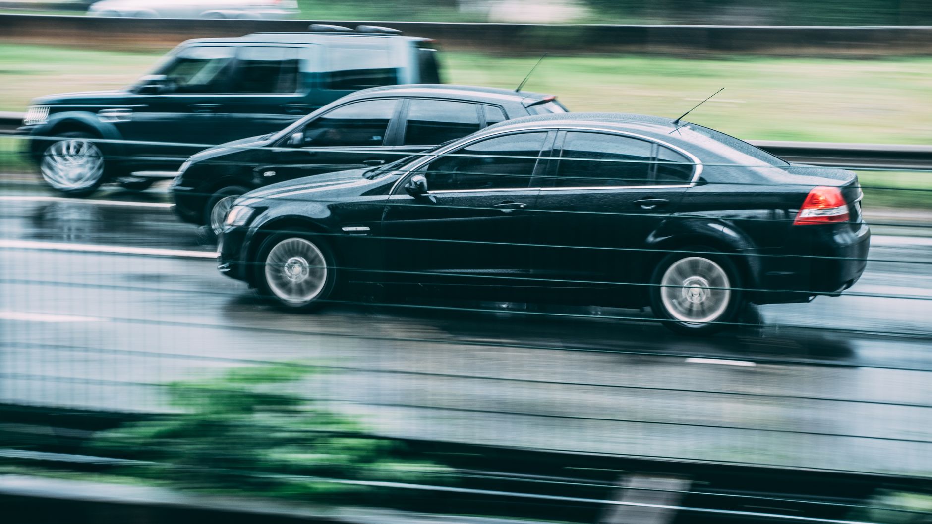 Dwa auta pędzące po mokrej autostradzie w rozmyciu ruchu