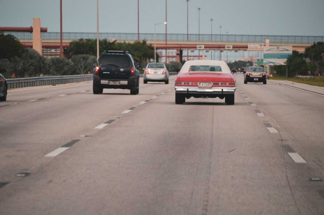 Ruch na autostradzie w Miami z klasycznym autem w miejskiej scenerii Ruch na autostradzie w Miami z klasycznym autem w miejskiej scenerii