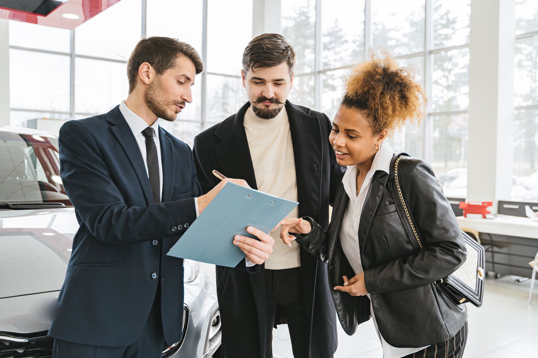 Trzech doradców omawia zakup Geely w nowoczesnym salonie