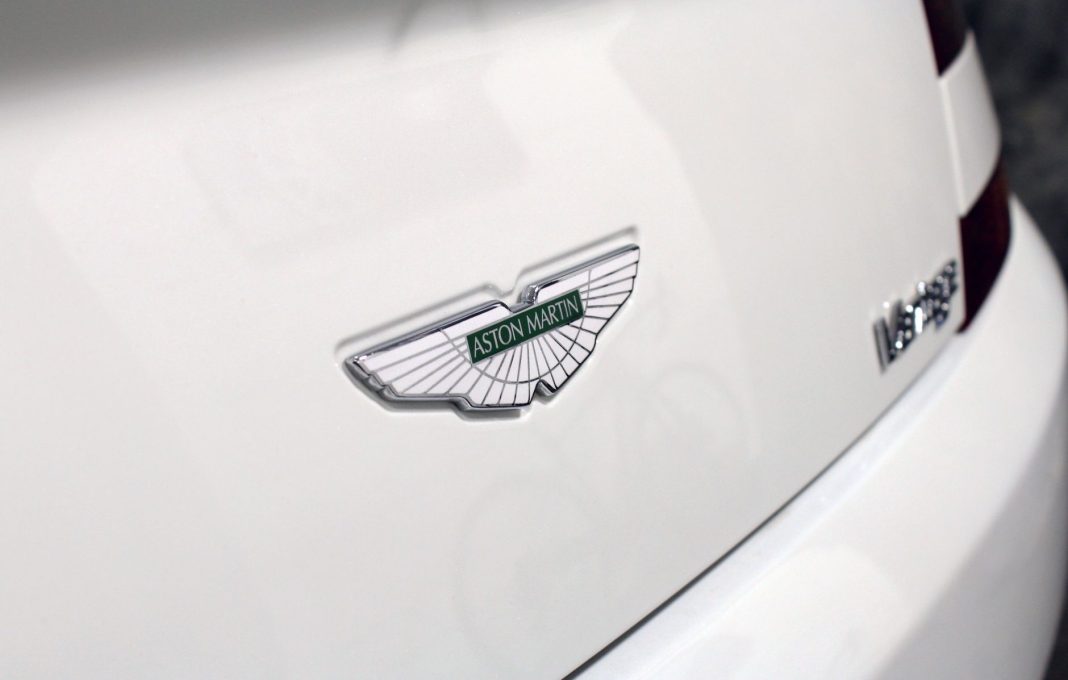 Logo Aston Martin na białym luksusowym samochodzie Logo Aston Martin na białym luksusowym samochodzie