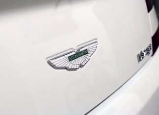 Logo Aston Martin na białym luksusowym samochodzie